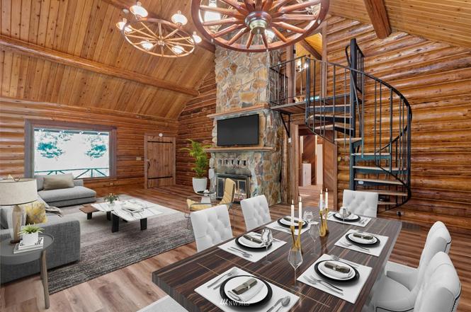 Open-concept log cabin great room with stone fireplace and spiral staircase