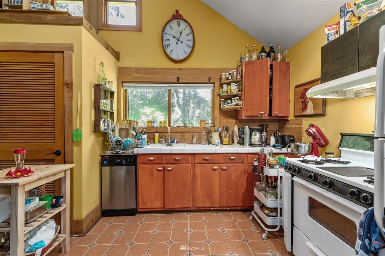 Rustic casita kitchen with wood cabinetry, yellow walls, and garden windows