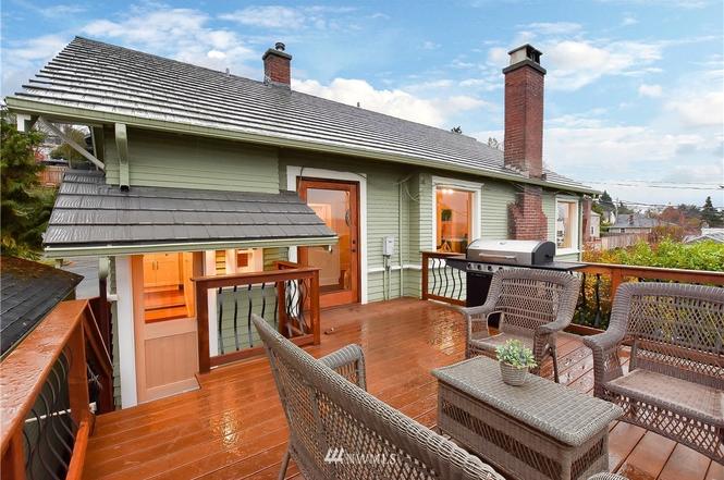 Expansive rooftop deck with outdoor seating and gas grill overlooking the city