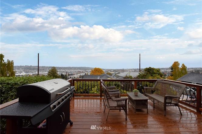 Deck lounge area with wicker seating and panoramic city and water views