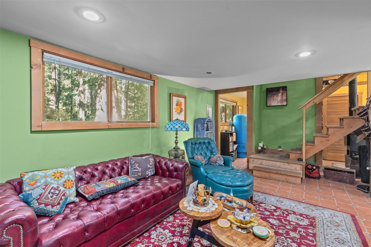 Colorful casita living room with leather sofa, chaise lounge, and forest views