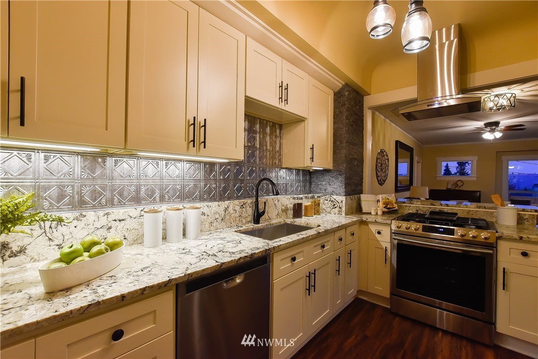 Chef's kitchen with cream cabinetry, granite counters, and stainless range