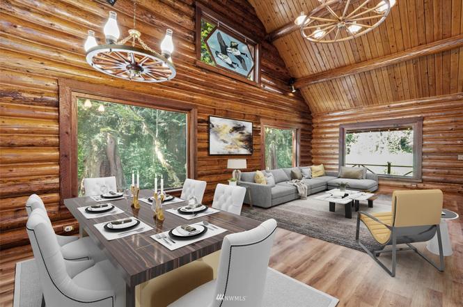 Dining and living area with vaulted wood ceilings and forest views