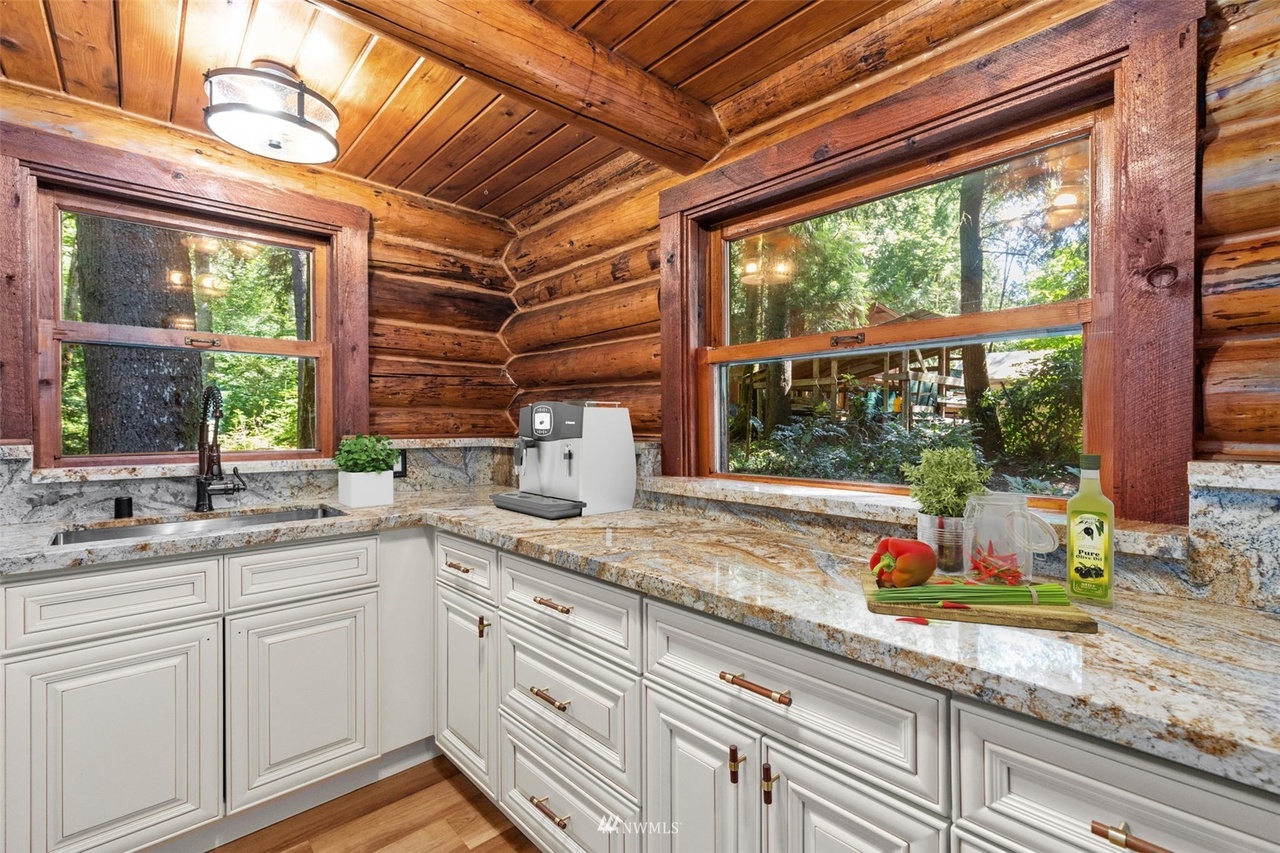 Bright cabin kitchen corner with forest views and modern finishes