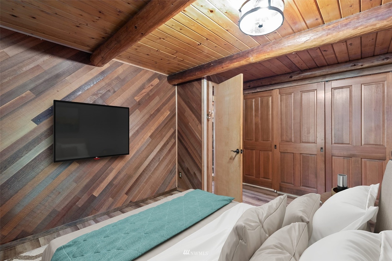Loft bedroom with reclaimed wood accent wall and closet