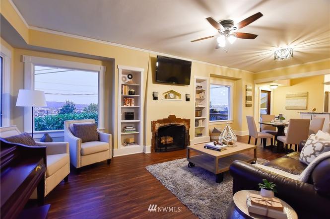 Bright living room with fireplace, built-ins, and city views