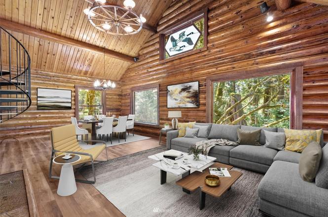 Spacious log cabin living room with oversized sectional and woodland windows